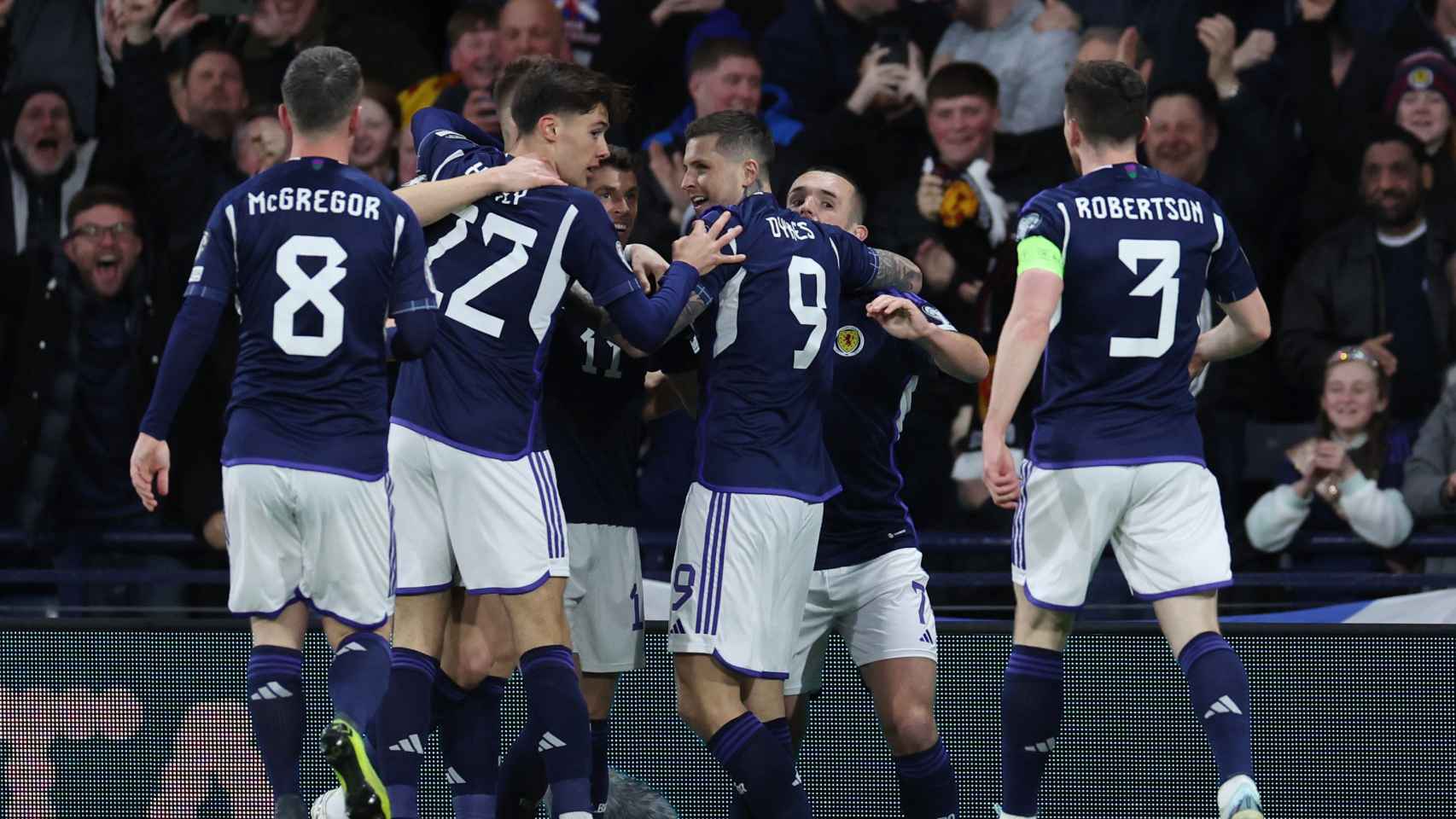 Piña de los jugadores de la selección de Escocia para celebrar el gol de McTominay