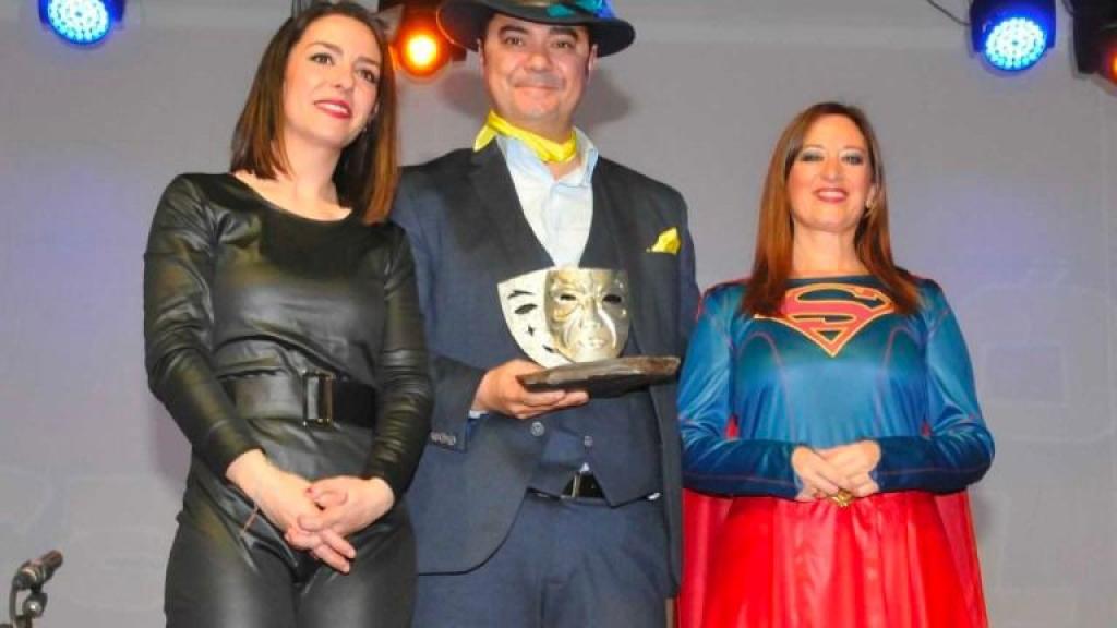 Juan Carlos Martínez, conocido en Málaga como 'El Negro', flanqueado por la edil Festejos, Inmaculada Expósito (disfrazada de Catwoman), y la regidora de Nuevas Poblaciones, Yolanda Reche (disfrazada de Superman), al recibir un premio en las fiestas de Carnaval de 2019.