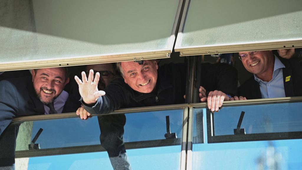 El expresidente brasileño Jair Bolsonaro saluda desde una ventana en la sede de su partido hoy, en Brasilia (Brasil).