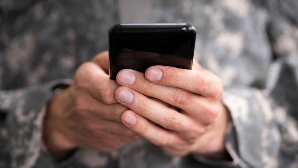 Un joven sostiene un teléfono móvil entre manos. Las nuevas tecnologías fomentan el acceso y distribución de pornografía.