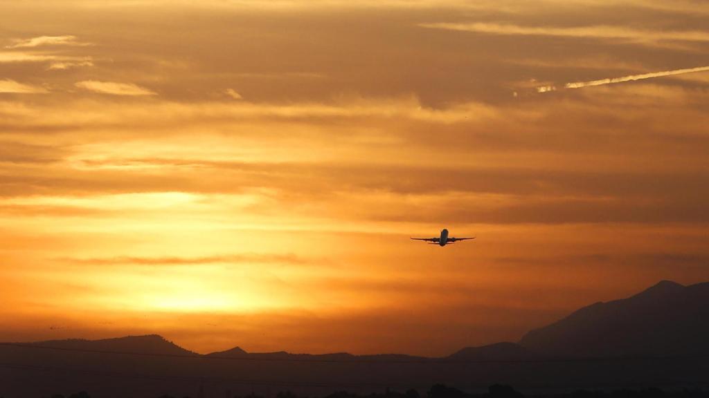 Avión despegando al atardecer en el aeropuerto alicantino de El Altet, este jueves.