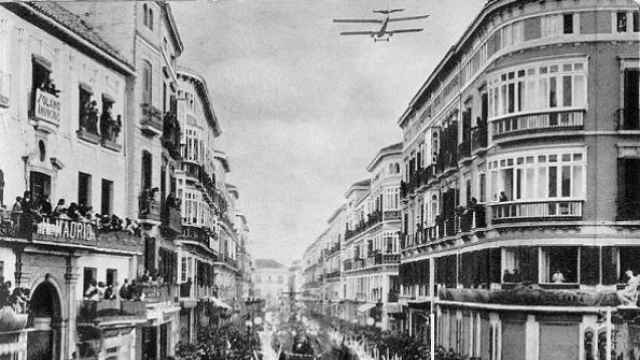 Un avión en la calle Larios tirando pétalos a los tronos en 1929.