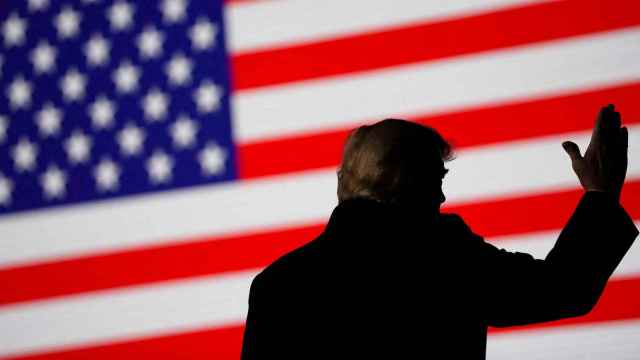 El expresidente de los Estados Unidos, Donald Trump, con la bandera del país frente a él.
