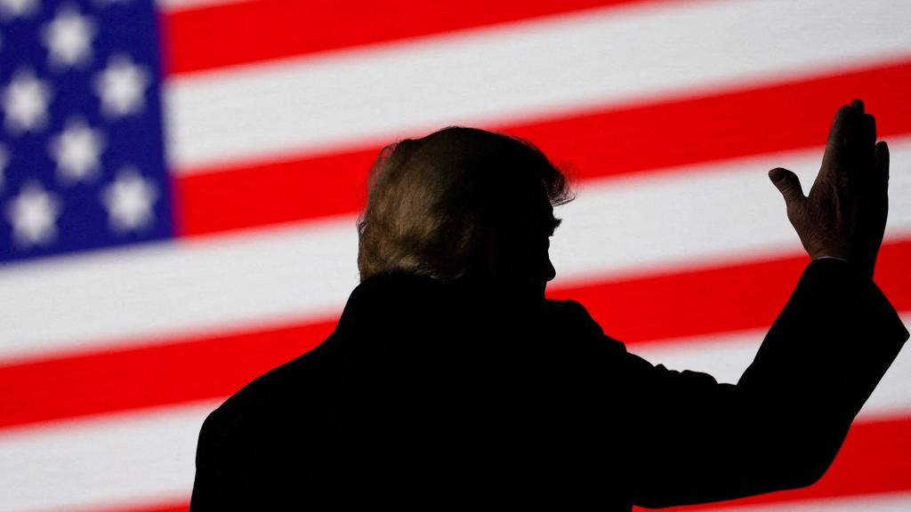 El expresidente de los Estados Unidos, Donald Trump, con la bandera del país frente a él.