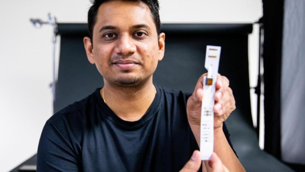 Anandghan Waghmare, autor principal del estudio, con una de las tiras reactivas adaptadas