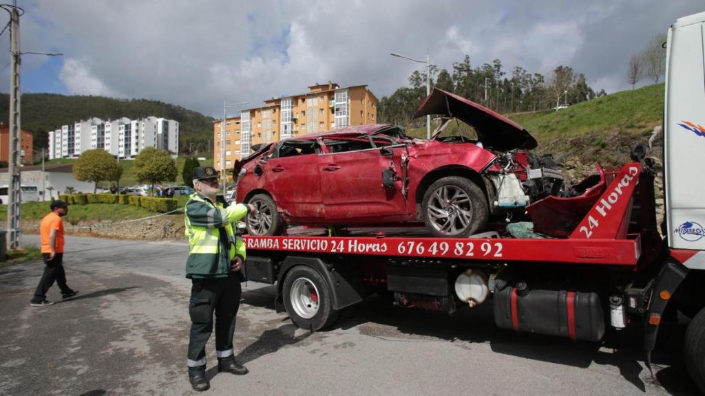 Un Guardia Civil vigila la retirada del coche siniestrado en el accidente.