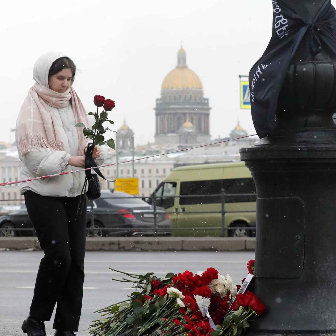 Una mujer deposita flores en un monumento improvisado en memoria del bloguero militar ruso Vladlen Tatarsky.