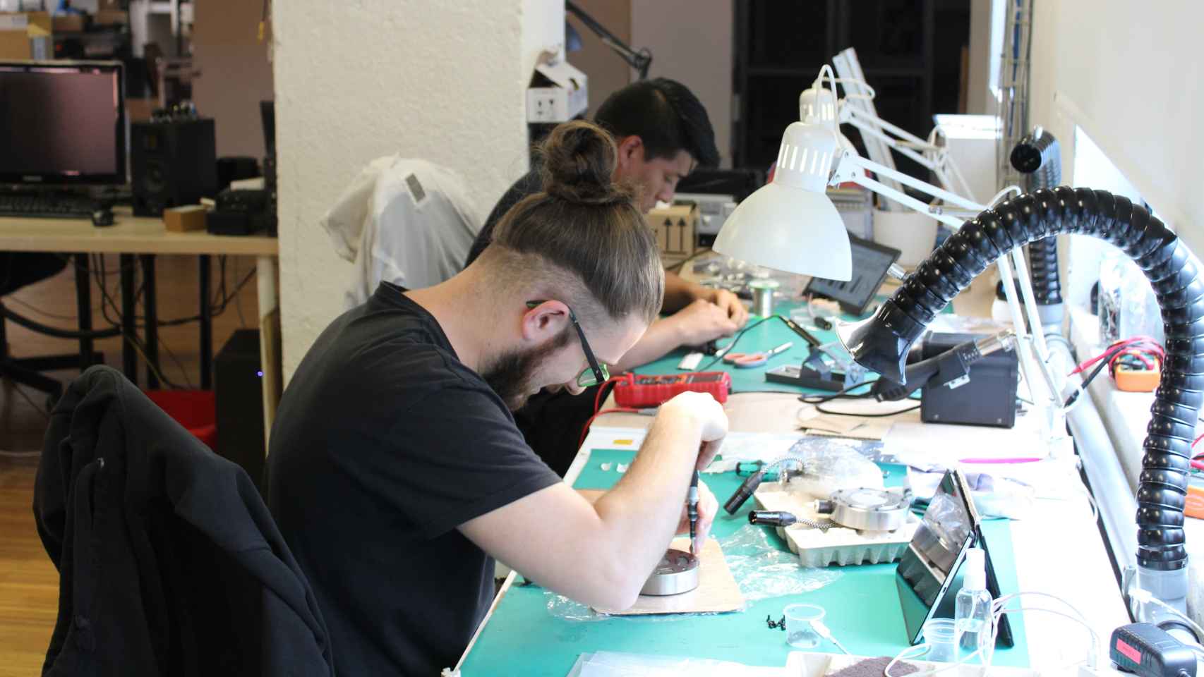 Álvaro Pérez y Brian Queza, dos trabajadores de TIERRA Audio, fabricando a mano los equipos de sonido de la marca.