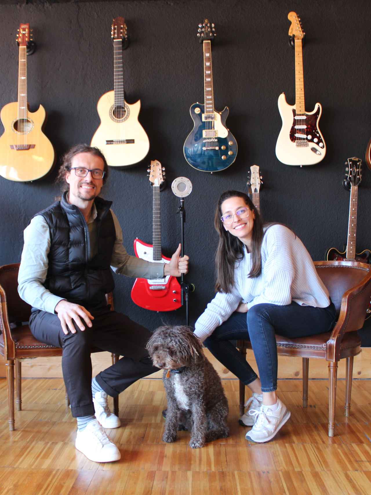 Javier Pascual y Esther Gutiérrez, cofundadores de TIERRA Audio, posando junto a un micrófono artesanal y su perra, Tina.