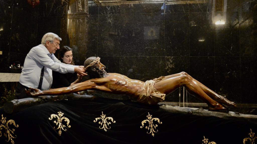 Ramón y Marta prueban la corona de espinas al Cristo de la Buena Muerte.