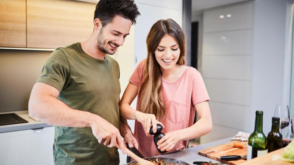 Pareja feliz cocinando juntos.