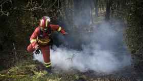 Un bombero trabaja en las tareas de extinción en el incendio de Las Regueras