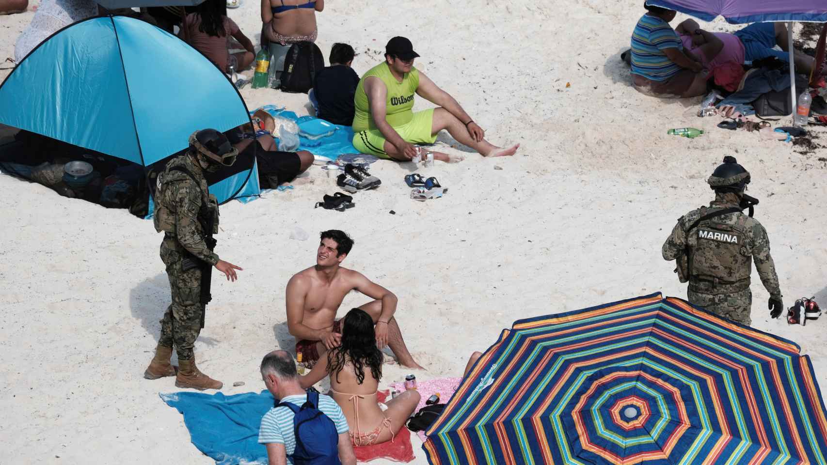 Un bañista habla con un marino mexicano en la playa Gaviota Azul de Cancún, esta Semana Santa.