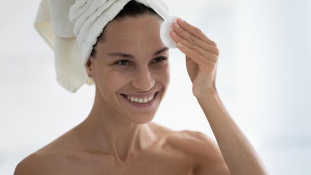 Mujer madura aplicándose sus productos de rutina cosmética.