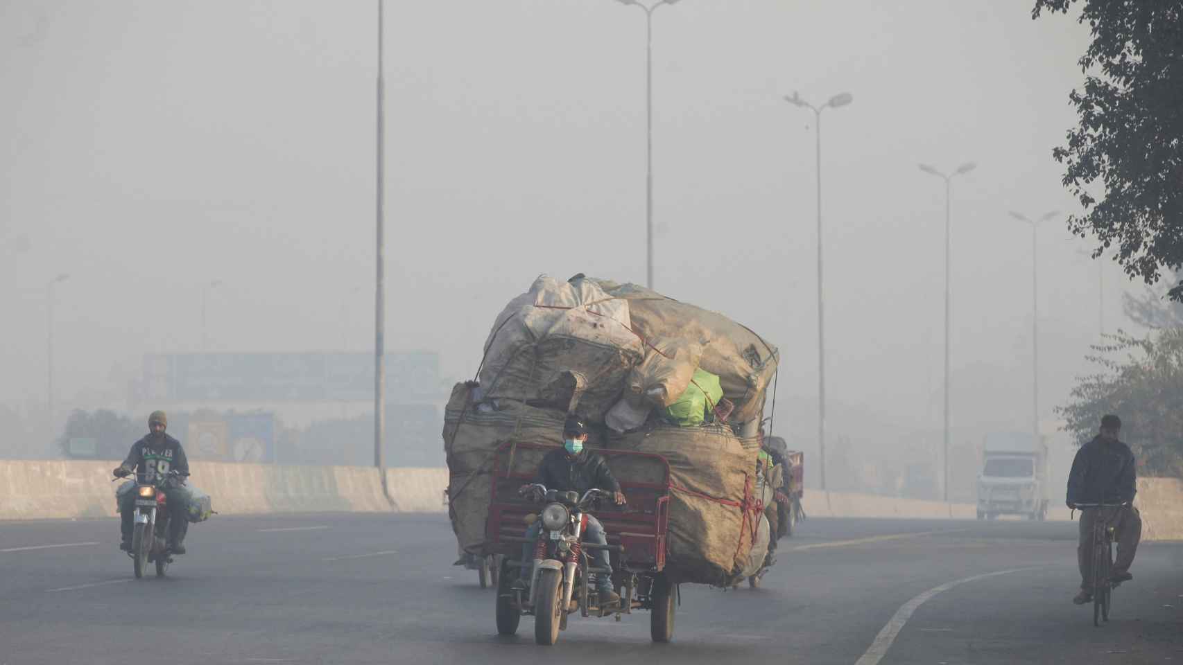 Un hombre conduce un triciclo durante un episodio de smog en Lahore (Pakistán) en 2021.