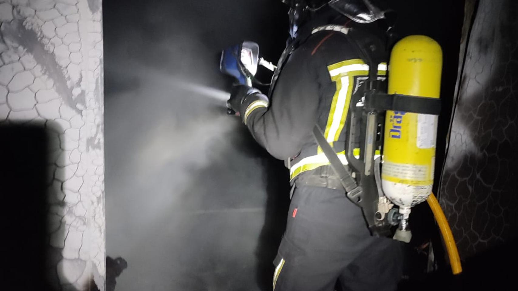 Un bombero entrando en la nave calcinada