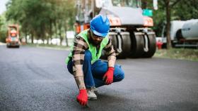 Un operario revisando el asfaltado de una calle