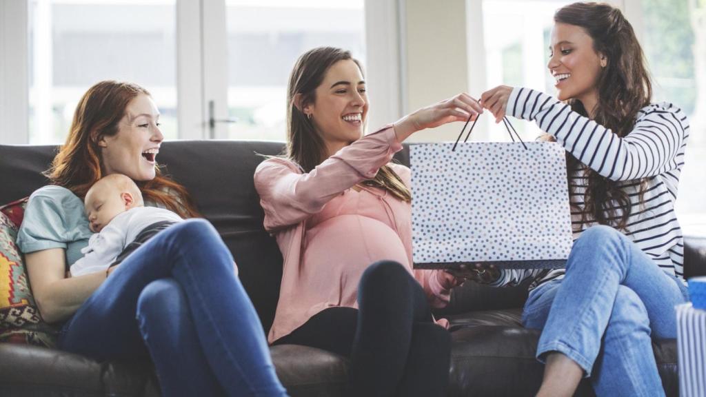 Mujer recibiendo regalos para su bebé.