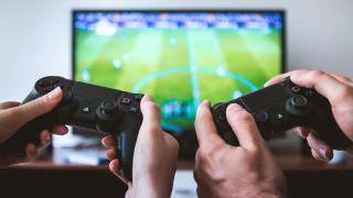 Dos personas jugando a la PlayStation.