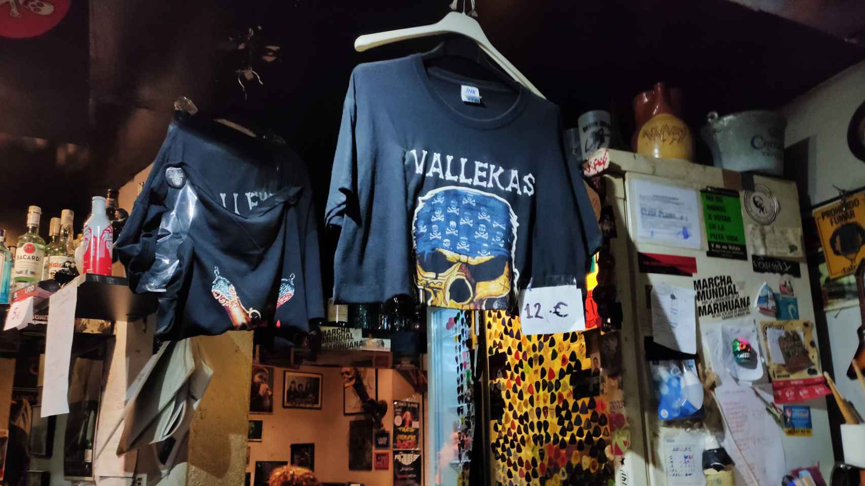 Camiseta de 'Vallekas' a la venta tras la barra del local. Al fondo, cientos de púas de guitarra.