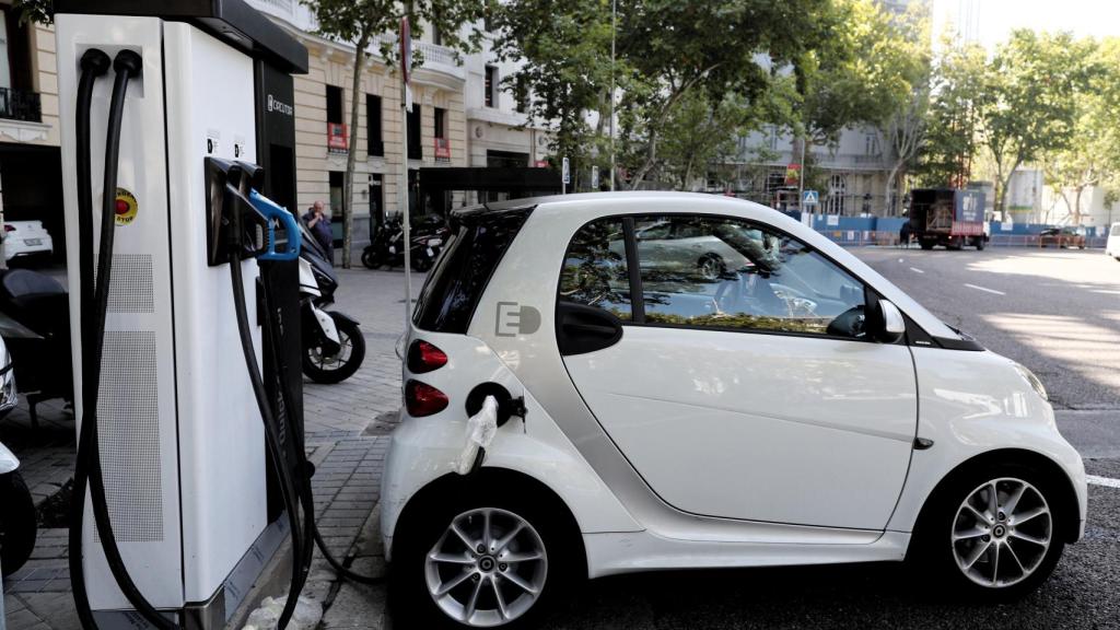 Un coche híbrido se carga en un punto de recarga de batería en Madrid.