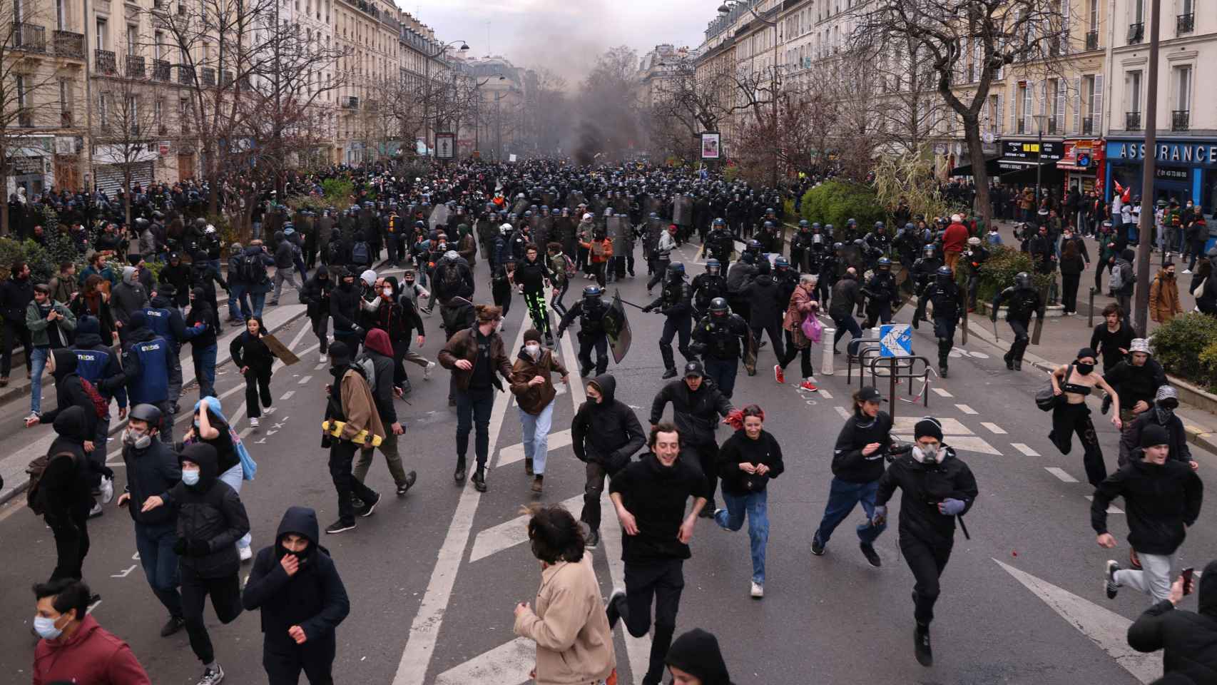 Cientos de manifestantes corren frente a la policía antidisturbios francesa durante los enfrentamientos como parte del undécimo día de huelgas y protestas nacionales contra la reforma de pensiones del gobierno francés, en París, Francia.