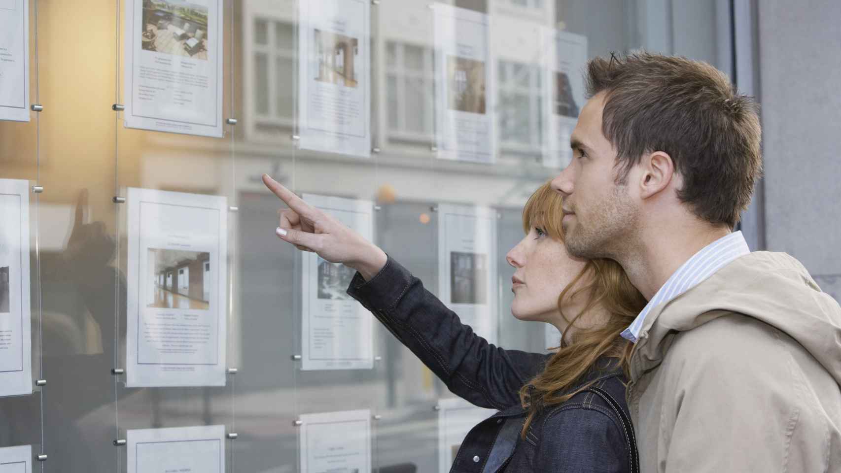 Una pareja se detiene frente a una agencia inmobiliaria, en una imagen de archivo.
