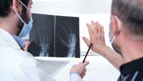 Un reumatólogo enseña una radiografía a un paciente, en una imagen de archivo.
