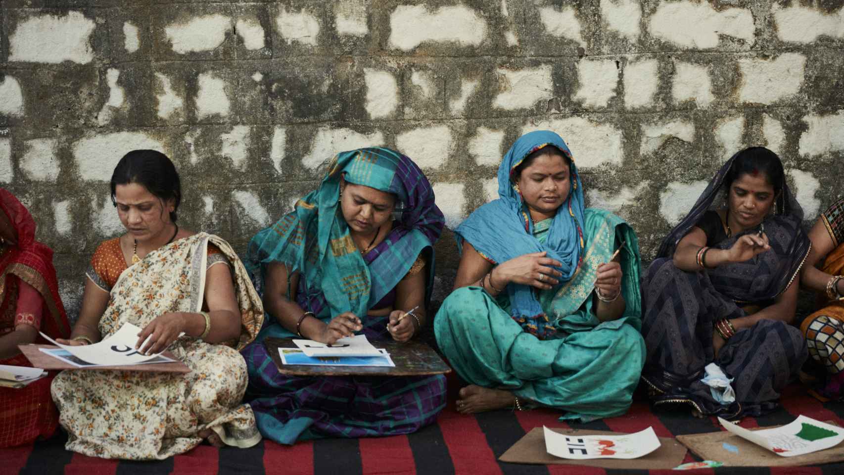 Un grupo de mujeres de la comunidad bhil pintando.