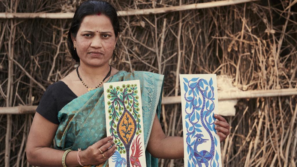 Gangubai Aamiliyar exhibiendo dos de sus creaciones artísticas.