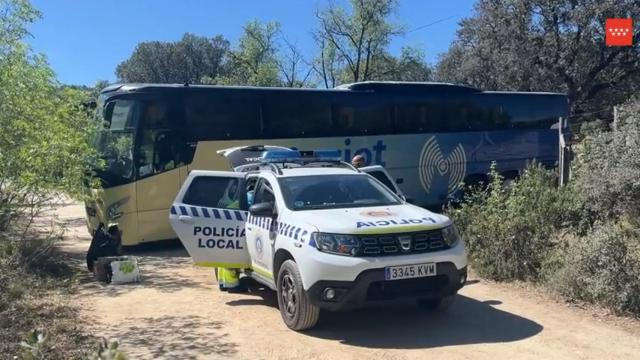 El autobús junto a un coche de Policía Local.