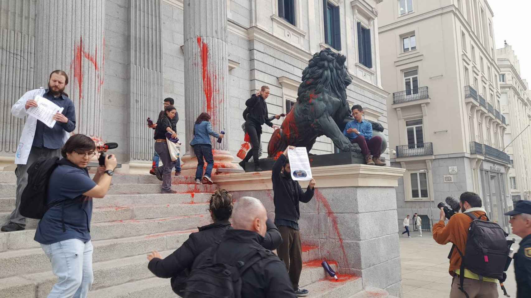 Los activistas climáticos pintando de rojo las puertas del Congreso el pasado 30 de marzo.