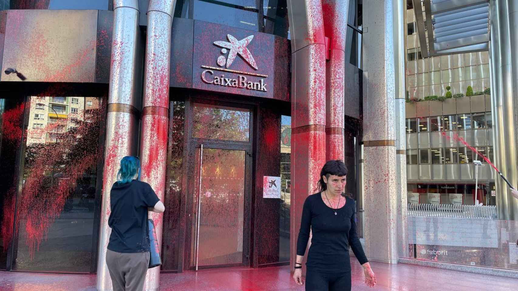 Dos activistas de Futuro Vegetal tiñen de rojo las puertas de una sede de CaixaBank.