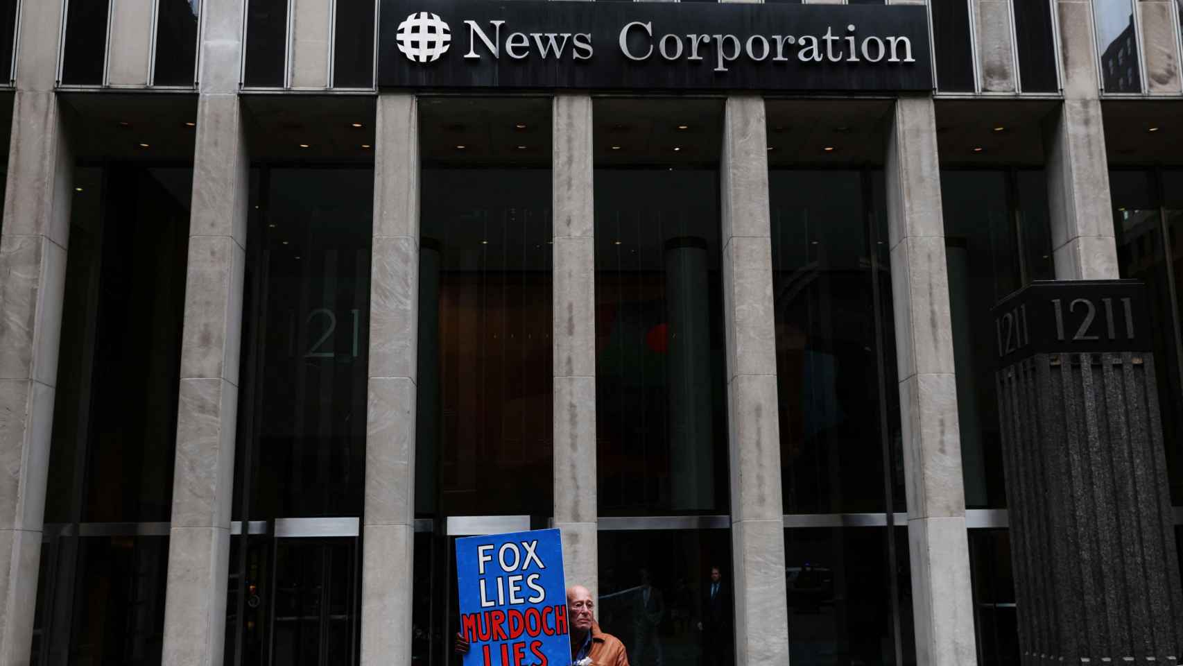 Un manifestante sostiene un cartel durante un mitin de Martes de la verdad frente al edificio de News Corporation en la ciudad de Nueva York.