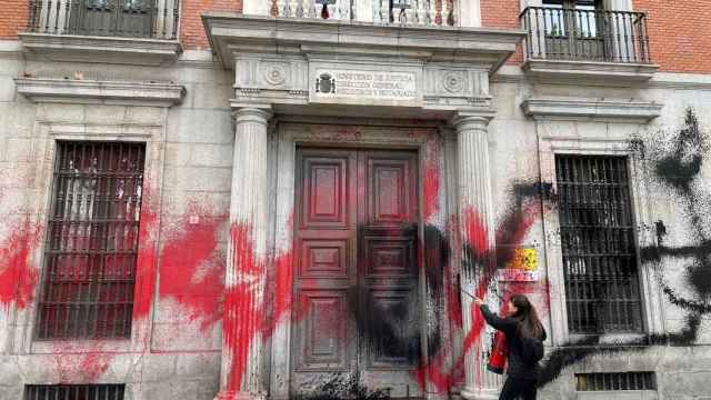 Una activista de Futuro Vegetal lanza pintura contra la sede de Ministerio de Justicia.