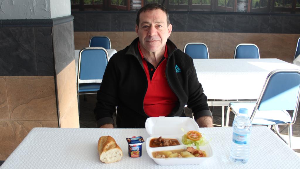 Francisco Porrero, dentro de la Bar de Paco, posando junto a su menú del día.