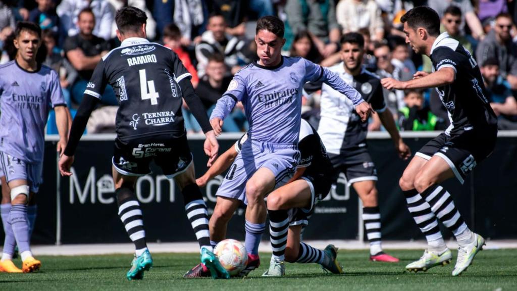 Sergio Arribas realiza un control con el Castilla ante la mirada de los jugadores de Unionistas.