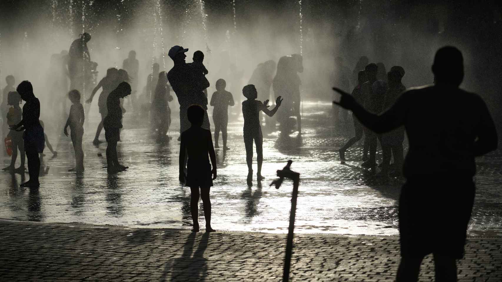 Varias personas en la fuente de Madrid Río durante una ola de calor en el verano de 2022.