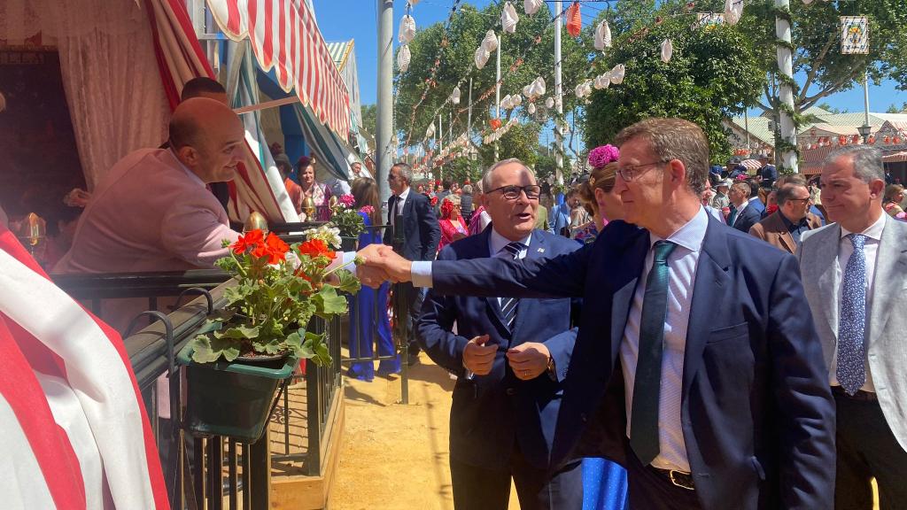 El presidente del PP, Alberto Núñez Feijóo, saluda a un feriante en la Feria de Abril.