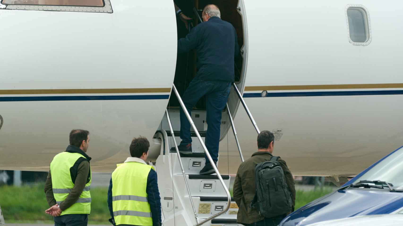 El Rey emérito Juan Carlos I sube las escaleras de un avión privado en el aeropuerto vitoriano de Foronda.
