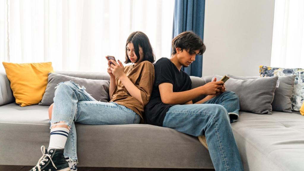 Pareja utilizando sus teléfonos móviles.