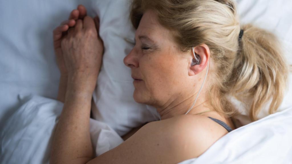 Una persona utilizando los auriculares mientras duerme.