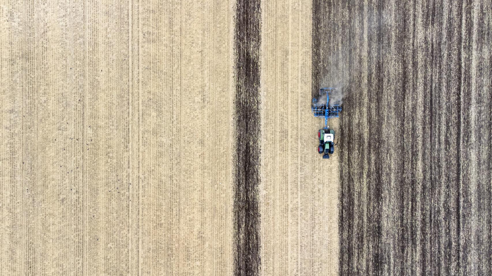 Vista aérea de un tractor cosechando campos de cereal