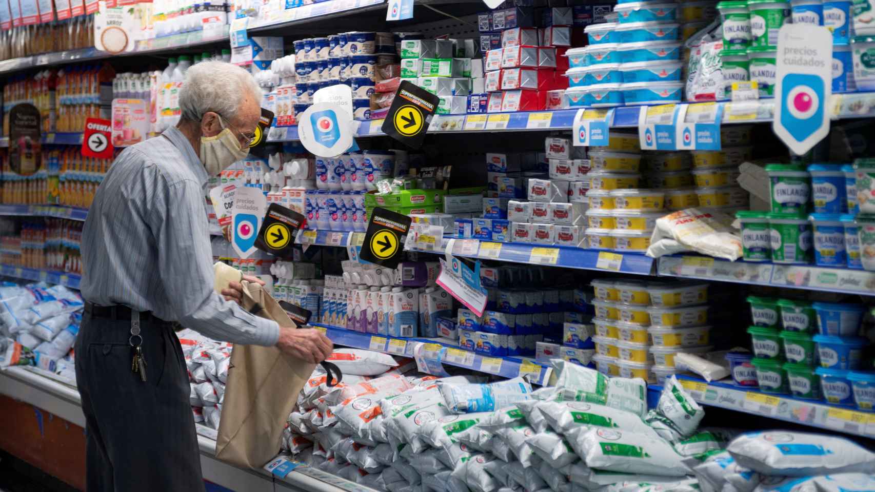 Un hombre junto a productos lácteos en un supermercado en el centro de Buenos Aires.
