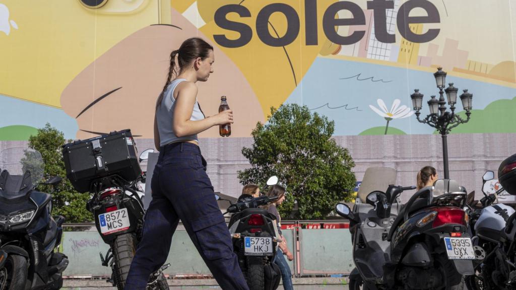 Una chica pasea bajo el sol y el calor de Madrid