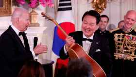 Yoon Suk Yeol con una guitarra que le ha regalado Joe Biden.