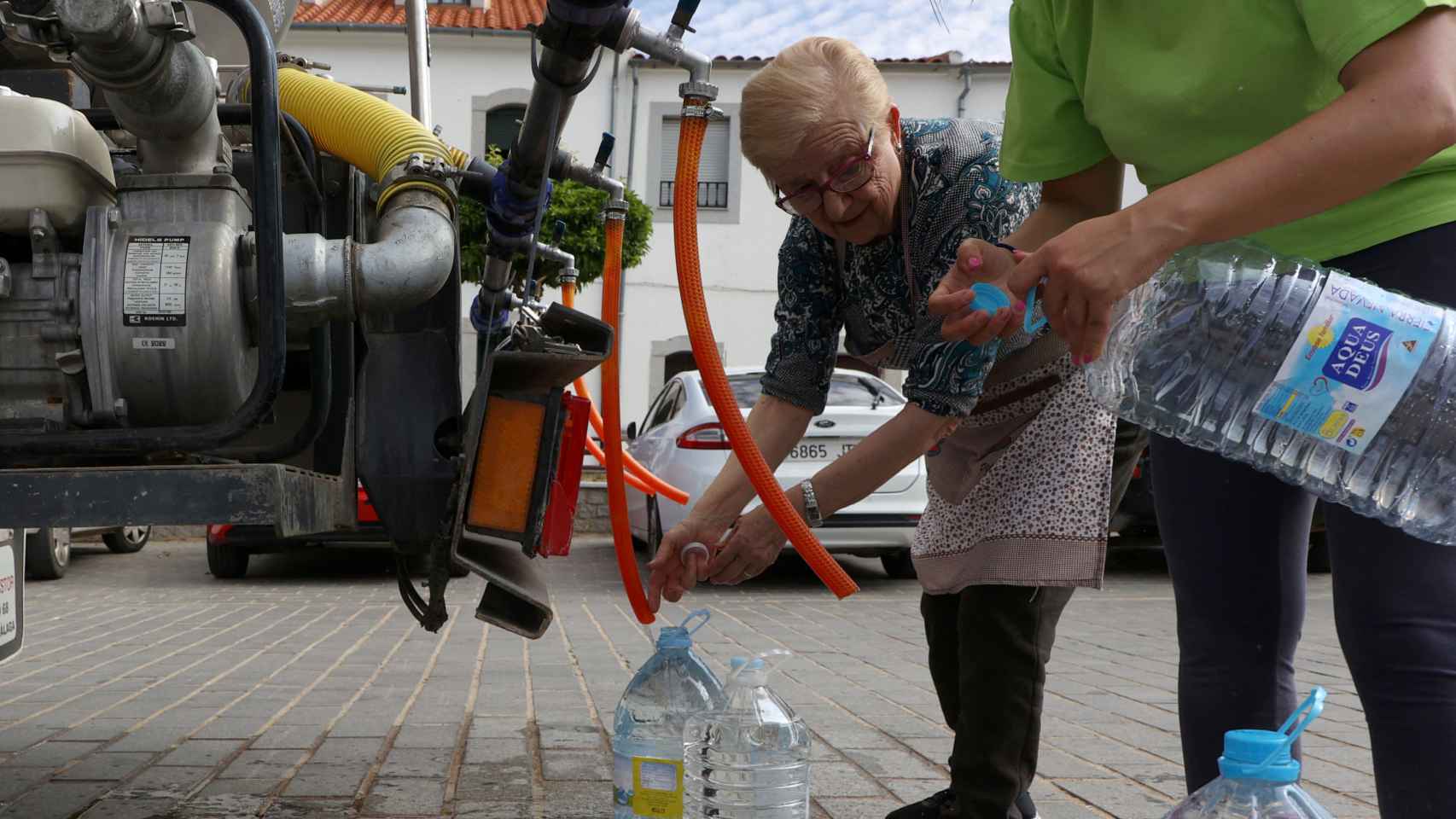 Varios vecinos de Alcaracejos recogen agua del camión cisterna, a 27 de abril.