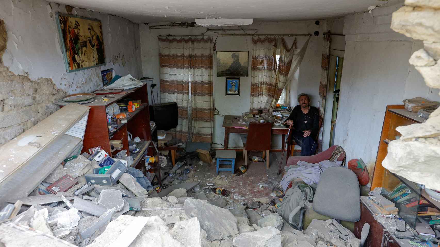 Un hombre en su casa, destrozada tras un bombardeo ruso, en Donetsk.