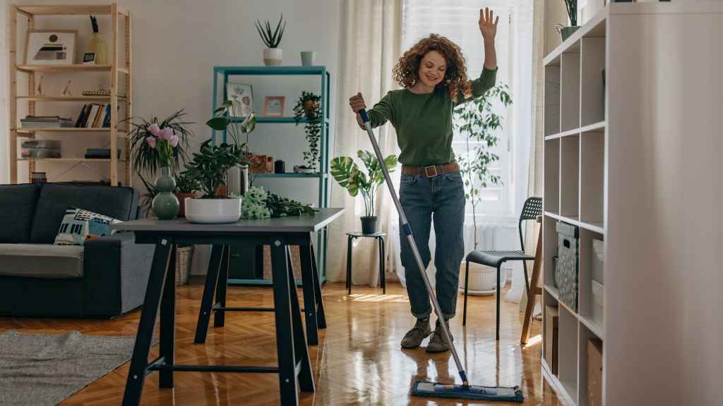 Una mujer limpiando su casa en primavera.