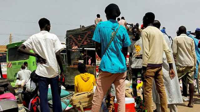 Un grupo de personas espera en Jartum, la capital de Sudán, para huir del país.